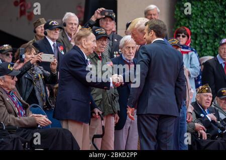 Präsident Donald J. Trump und der französische Präsident Emmanuel Macron grüßen Veteranen des Zweiten Weltkriegs beim 75. Gedenken an den D-Day am Donnerstag, den 6. Juni 2019, auf dem amerikanischen Friedhof der Normandie in der Normandie. Präsident Trump bei DDay75 Stockfoto