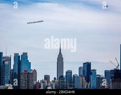 New York, Usa . April 2020. Ein Flugzeug, das ein 50-Fuß-Banner mit der Aufschrift #CAPITALISMISTHEPANDEMIC zog, flog am 3. Mai 2020 über Manhattan. Die Organisatoren der Luftaktion wollten eine Botschaft an das Fundament des Kapitalismus und der Banken senden und gegen die Kolonisierung und die Ungerechtigkeit der Arbeiter protestieren, die "während dieser Coronavirus-Pandemie nicht angemessen geschützt oder unterstützt werden". (Foto: Michael Nigro/Sipa USA) Quelle: SIPA USA/Alamy Live News Stockfoto