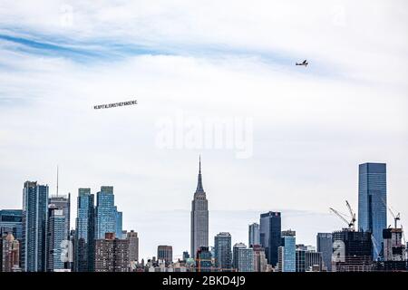 New York, Usa . April 2020. Ein Flugzeug, das ein 50-Fuß-Banner mit der Aufschrift #CAPITALISMISTHEPANDEMIC zog, flog am 3. Mai 2020 über Manhattan. Die Organisatoren der Luftaktion wollten eine Botschaft an das Fundament des Kapitalismus und der Banken senden und gegen die Kolonisierung und die Ungerechtigkeit der Arbeiter protestieren, die "während dieser Coronavirus-Pandemie nicht angemessen geschützt oder unterstützt werden". (Foto: Michael Nigro/Sipa USA) Quelle: SIPA USA/Alamy Live News Stockfoto