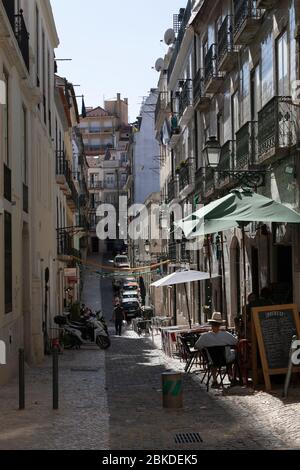 Schmale Straße mit alten Wohnhäusern und einem Restaurant im Freien, Bairro Alto (Oberer Bezirk), Lissabon, Portugal Stockfoto