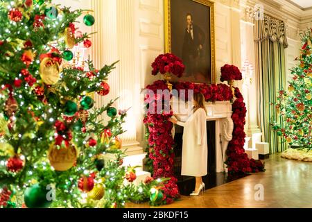 Am 1. Dezember 2019 überprüfte First Lady Melania Trump die Weihnachtsdekoration im State Dining Room des Weißen Hauses. Sie bewundert eine Rosengirlande als Teil der jährlichen Tradition der Vorbereitung auf die Feiertage im Weißen Haus. Stockfoto