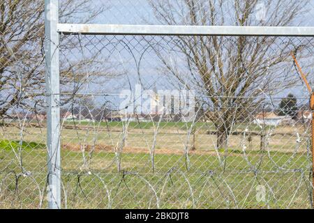 Ungarisches Dorf durch den Grenzzaun zwischen Rastina (Serbien) und Bacsszentgyorgy (Ungarn) gesehen. Diese Grenzmauer wurde gebaut, um das Eingehen zu stoppen Stockfoto