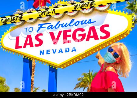 Frau mit einer chirurgischen Maske während Covid-19 zeigt Willkommen bei fabelhaften Las Vegas Nevada Zeichen. Nevada, USA während der SARS-CoV-2-Pandemie Stockfoto