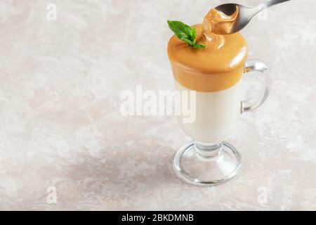 Dalgona schaumig Kaffee in Glas auf hellem Hintergrund. Trend koreanisch Iced Latte Kaffee Getränk mit Schaum von Instant-Kaffee mit Kopierraum für Text. Stockfoto