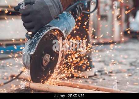 Bauarbeiter mit Winkelschleifer Schneiden von Metall auf der Baustelle. Stockfoto
