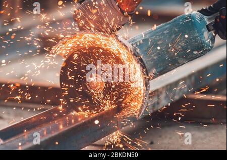 Bauarbeiter mit Winkelschleifer Schneiden von Metall auf der Baustelle. Stockfoto