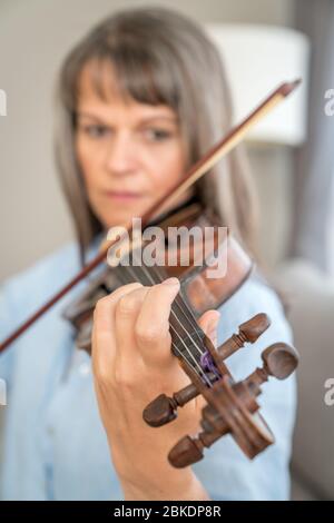 Reife Frau spielt Geige. Konzentrieren Sie sich auf die Finger Stockfoto