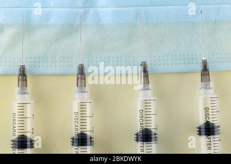 Injektion über einen Tisch mit Medikamenten und Coronavirus Bluttest. Impfkonzept. Stockfoto