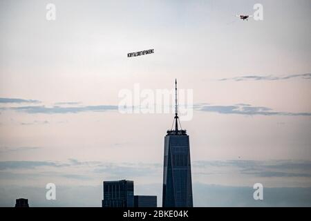 New York, Usa. Mai 2020. Ein Flugzeug, das ein 50-Fuß-Banner mit der Aufschrift #CAPITALISMISTHEPANDEMIC zog, flog am 3. Mai 2020 über Manhattan. Die Organisatoren der Luftaktion wollten eine Botschaft an das Fundament des Kapitalismus und der Banken senden und gegen die Kolonisierung und die Ungerechtigkeit der Arbeiter protestieren, die "während dieser Coronavirus-Pandemie nicht angemessen geschützt oder unterstützt werden". (Foto: Michael Nigro/Pacific Press) Quelle: Pacific Press Agency/Alamy Live News Stockfoto