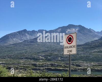 Warnschild für Lawinenbereich entlang des Klondike Highway, nördlich von Skagway, Alaska. Das Foto wurde im Sommer auf einer Kreuzfahrt zum White Pass Summit aufgenommen Stockfoto