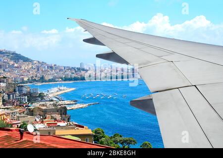 Reisekonzept. Luftaufnahme von Neapel und Mittelmeer, Italien. Blick aus dem Fenster eines Flugzeugs. Panoramalicht mit Flügel eines Flugzeugs Stockfoto