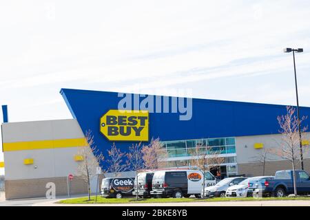 Best Buy Schaufenster mit der Geek Squad Fahrzeuge auf dem Parkplatz geparkt gesehen. Seit der COVid19-Pandemie sind die meisten Geschäfte geschlossen. Stockfoto