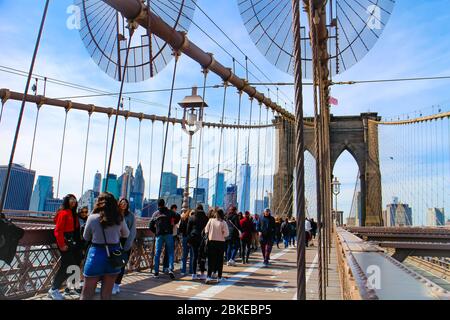 Überqueren Sie die Brooklyn Bridge mit Touristenbesichtigung und Blick auf die Skyline von Lower Manhattan mit dem One World Trade Center. Stockfoto