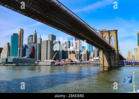 Ikonischer Blick von Brooklyn unter der Brooklyn Bridge auf die Skyline von Lower Manhattan. Stockfoto