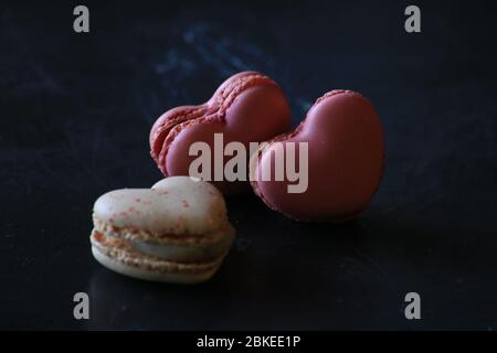 Herzförmige Makronen auf dunklem Hintergrund. Makronen Herz. Valentinstag. Stockfoto