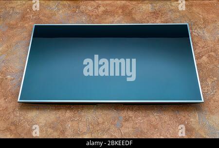 Großer Blindblick, abgestellt von lcd-Fernseher an orangefarbener Wand, Ansicht von vorne unten Stockfoto