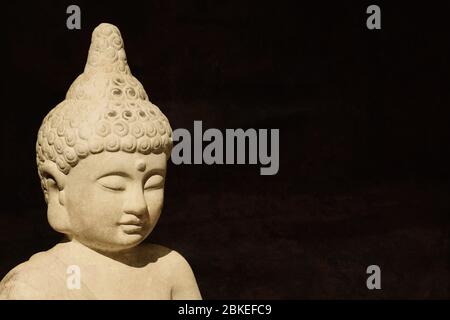 buddha Statue Kopf aus Stein - buddhismus Meditation Erleuchtung Religion Glaube und Spiritualität Konzept - schwarzer Hintergrund mit Kopie Raum Stockfoto