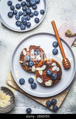 Tofu Käsekuchen mit Blaubeeren auf einem grauen Teller. Gesundes veganes Food-Konzept. Stockfoto