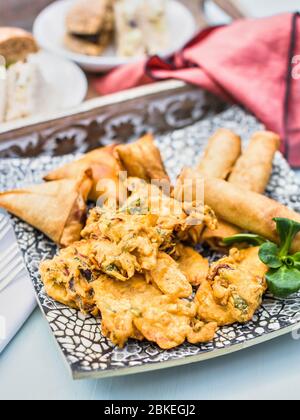 Indische Küche, indische Küche. Pakora Samosa und Frühlingsrollen traditionelle indische gebratene Snacks, Vorspeise auf einem Gericht serviert. Authentische asiatische Küche. Reisen Stockfoto