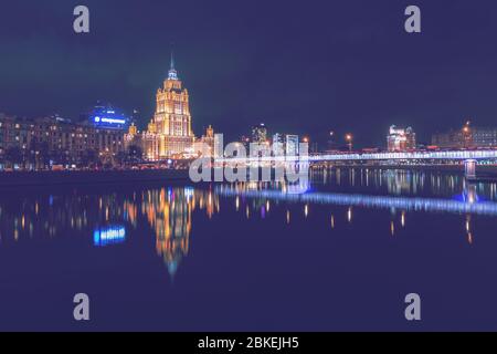 Hotel Ukraine oder Radisson, spiegelt sich in der Moskau River. Nachtlichter und Beleuchtung am Damm. Moskau, Russland. Stockfoto