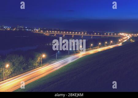 Fahrender Wagen mit Unschärfe-Licht durch die Stadt der Dämmerung. Nächtliches Stadtbild. Stockfoto