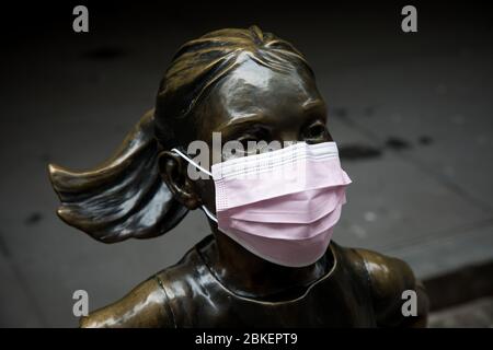 (200504) -- PEKING, 4. Mai 2020 (Xinhua) -- die Statue des Fearless Girl wird mit einer Gesichtsmaske vor der New York Stock Exchange (NYSE) während der COVID-19 Pandemie in New York, USA, am 27. April 2020, gesehen. ZU XINHUA SCHLAGZEILEN VOM 4. MAI 2020. (Foto von Michael Nagle/Xinhua) Stockfoto