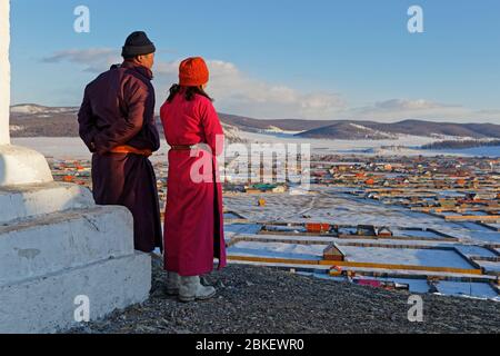KHATGAL, MONGOLEI, 2. März 2020 : EIN mongolisches Paar in traditioneller Kleidung, das von einem Hügel aus ihre Stadt betrachtet. Stockfoto