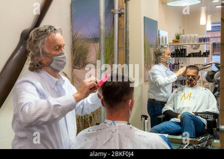 Friseursalon in Essen-Rüttenscheid, erster Kunde nach 6 Wochen, Geschäft wegen Koronakrise geschlossen, Meisterfriseur und Kunde mit Mund n Stockfoto