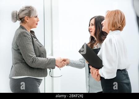 Nahaufnahme: Zwei Geschäftsfrauen grüßen sich mit einem Handschlag Stockfoto