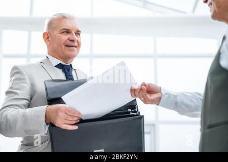 Bis zu schließen. Geschäftsmann empfangen Dokument von Mitarbeiter der Bank. Stockfoto