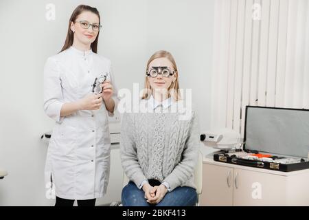 Augenarzt Frau Arzt Kontrollen diagnostizieren Sehvermögen Myopie, Hyperopie junge Frau. Konzept Auswahl von Brillen und Linsen. Stockfoto