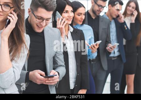 Eine Gruppe verschiedener Jugendlicher nutzt ihr Smartphone Stockfoto