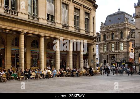 Die Leute im Cafe Bar Nemours mit dem Louvre im Hintergrund, Place Colette, Paris, frankreich Stockfoto