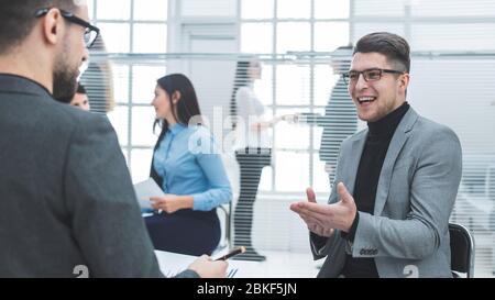 Junger Geschäftsmann, der seine Ideen mit einem Kollegen diskutiert Stockfoto