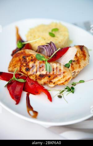 Gegrilltes Hähnchenfilet und Pfeffer. Fleisch und Brei in einer Platte mit microgreen. Weißer Teller mit Hausnahrung aus der Nähe. Schnitzel und Gemüse. Zerdrückt Stockfoto