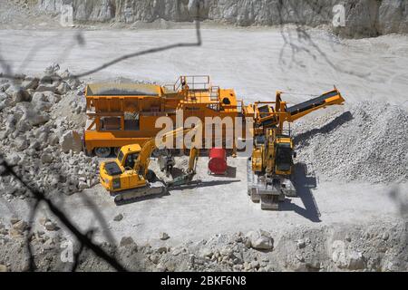 Mit Blick auf einen hellen Kreidebruch zu den schweren Maschinen, die wie Spielzeug aussehen Stockfoto