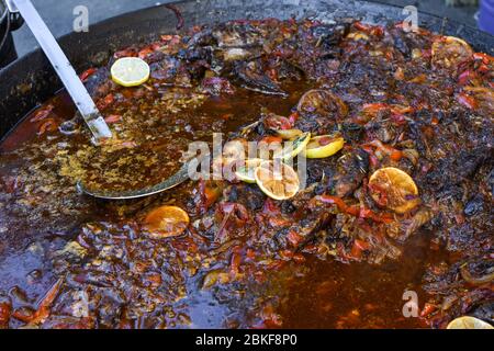 Traditioneller Fischeintopf, der in einer rustikalen Schüssel auf Holzhintergrund zubereitet wird. Frisches Essen Buffet Brunch Catering Essen Party Sharing Konzept Stockfoto