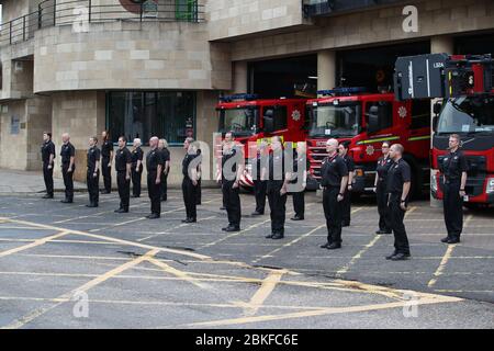 Grüne Uhr und Bahnhofsmitarbeiter an der Tollcross Community Fire Station in Edinburgh beobachten eine Schweigeminute , in Erinnerung an ihre Kollegen, die am Feuerwehrgedenkenstag ihr Leben verloren haben. Stockfoto