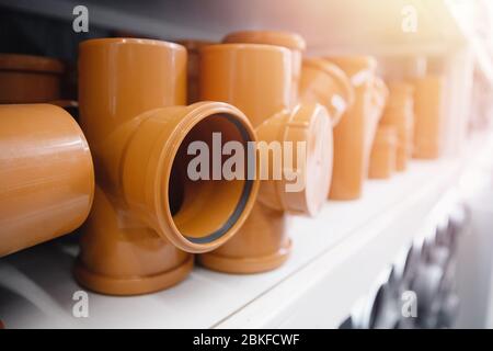 PVC-Kunststoffbauleitungen für Wasser sind in Reihe auf dem Zähler dargestellt. Hintergrund unscharf machen. Stockfoto