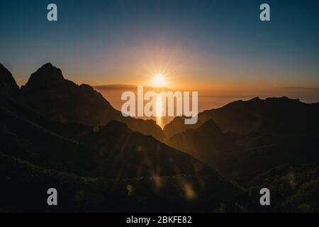 Roter Sonnenuntergang über Bergen und Meer Stockfoto