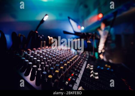 Sound Equipment DJ-Konsole. Hintergrund verschwommen. Blaue und lila Farben, hell erleuchteter Scheinwerfer. Stockfoto