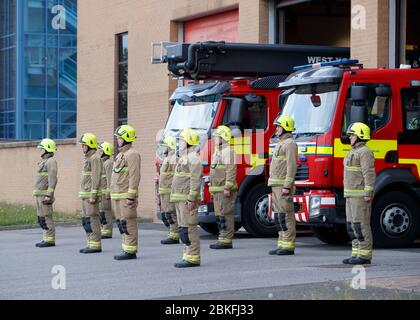 Leeds Green Beobachten Sie Feuerwehrleute beobachten eine Schweigeminute vor der Leeds Fire Station in Kirkstall Rd, in Erinnerung an ihre Kollegen, die ihr Leben in der Dienstlinie verloren haben. Stockfoto