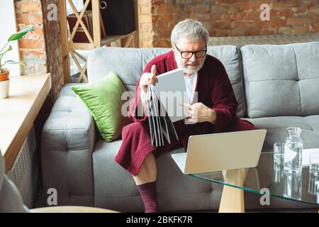 Arbeiten von zu Hause aus. Senior Mann während der Quarantäne, zu erkennen, wie wichtig zu Hause bleiben während des Virus Ausbruch. Konzept der Sperrung von Coronavirus, Selbstisolierung, Gesundheit, Sicherheit, Schutz. Stockfoto