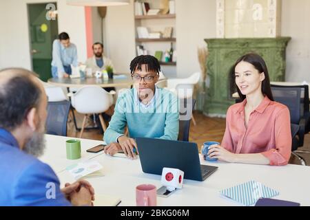 Gruppe von modernen Geschäftsleuten, die am Büroschreibtisch zusammen an einem neuen Projekt arbeiten Stockfoto