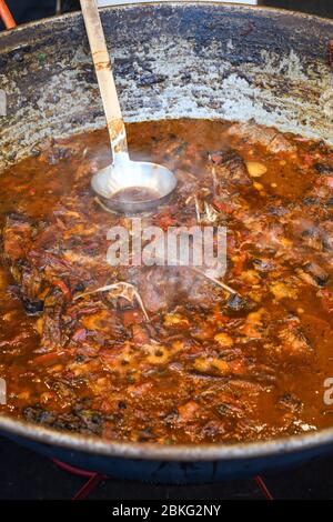 Traditioneller Fischeintopf, der in einer rustikalen Schüssel auf Holzhintergrund zubereitet wird. Frisches Essen Buffet Brunch Catering Essen Party Sharing Konzept Stockfoto