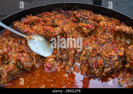 Traditioneller Fischeintopf, der in einer rustikalen Schüssel auf Holzhintergrund zubereitet wird. Frisches Essen Buffet Brunch Catering Essen Party Sharing Konzept Stockfoto