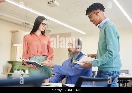 Junge afroamerikanischen Mann und kaukasische Frau zeigt einige Arbeitsergebnisse Chef-Manager Stockfoto