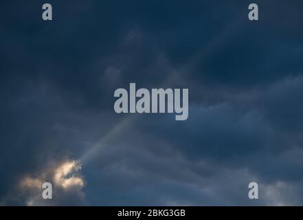 Sieversdorf, Deutschland. Mai 2020. Ein Sonnenstrahl scheint aus einer Öffnung zwischen dunklen Wolken am Himmel. Quelle: Patrick Pleul/dpa-Zentralbild/ZB/dpa/Alamy Live News Stockfoto