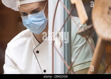 Dresden, Deutschland. Mai 2020. Am Eingang einer Bäckerei sitzt eine Modepuppe mit Mundschutz. In der Corona-Krise gibt es weitere Loosierungen in Sachsen. Quelle: Sebastian Kahnert/dpa-Zentralbild/dpa/Alamy Live News Stockfoto