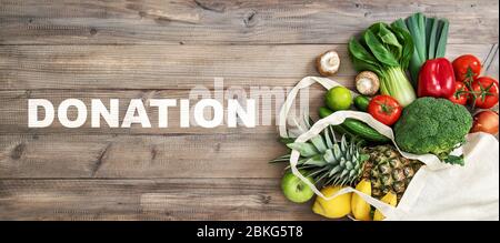 Lebensmittelspende. Gesunde Ernährung Obst Gemüse in Koton Beutel auf Holzhintergrund Stockfoto